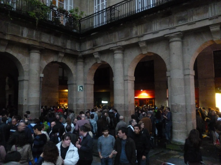 an open courtyard at night with many people in it