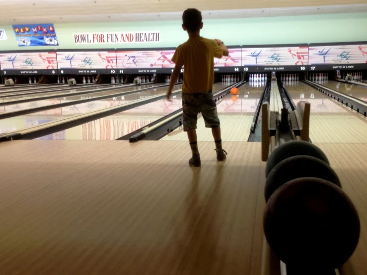 a young man standing on top of a bowling alley