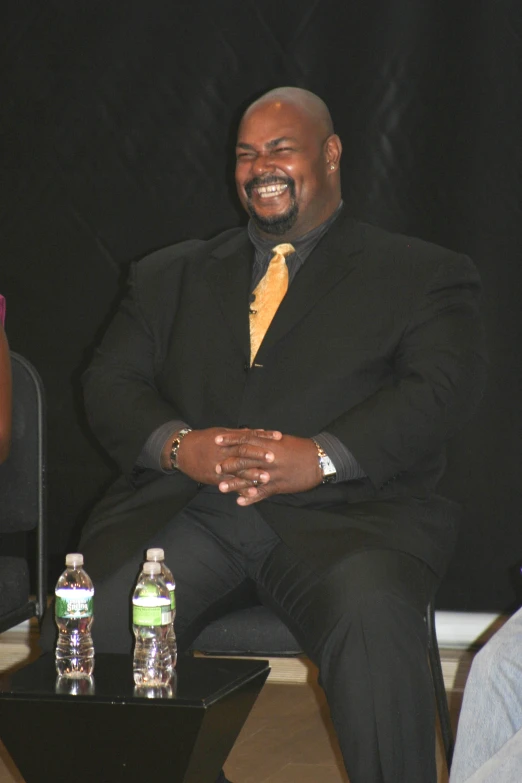 two people sitting next to each other, one wearing a suit and tie