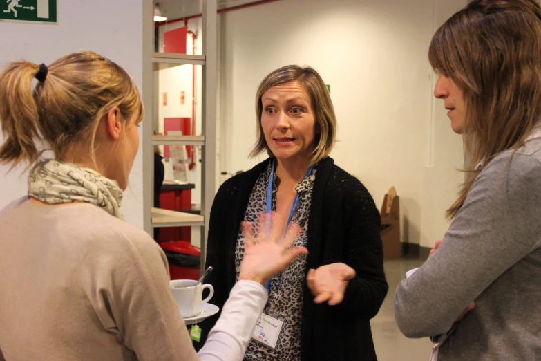 three women stand together in an office lobby