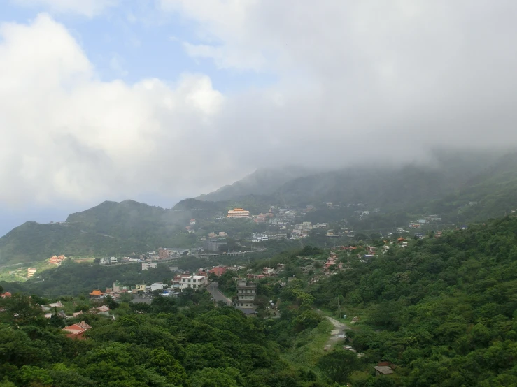 many buildings on a hill are near the clouds