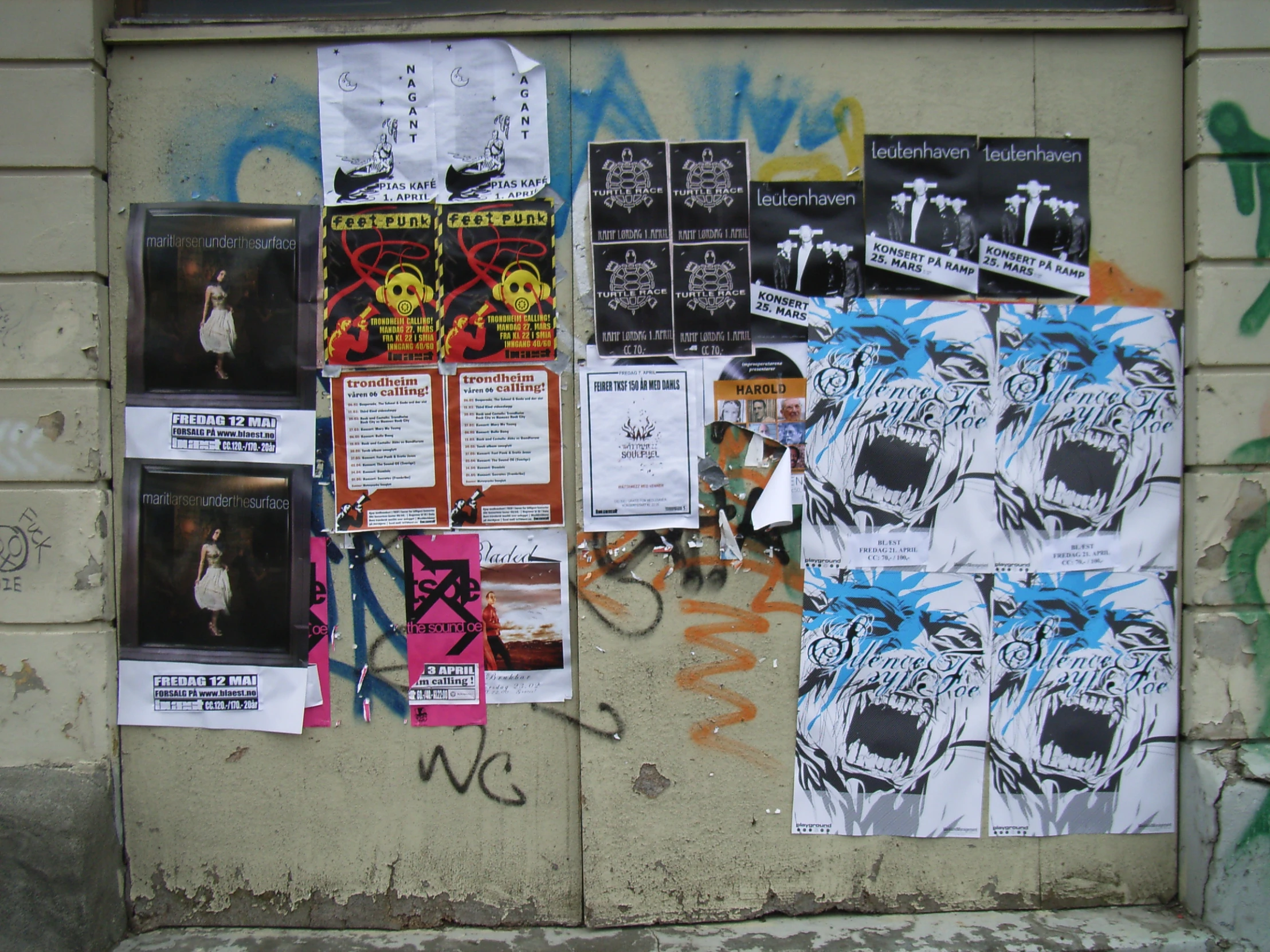 several posters on the side of a wall