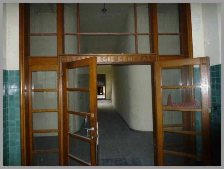 a hallway with glass and wood doors leading into a cell