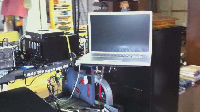 a laptop is on a desk that has many wires hooked up in it