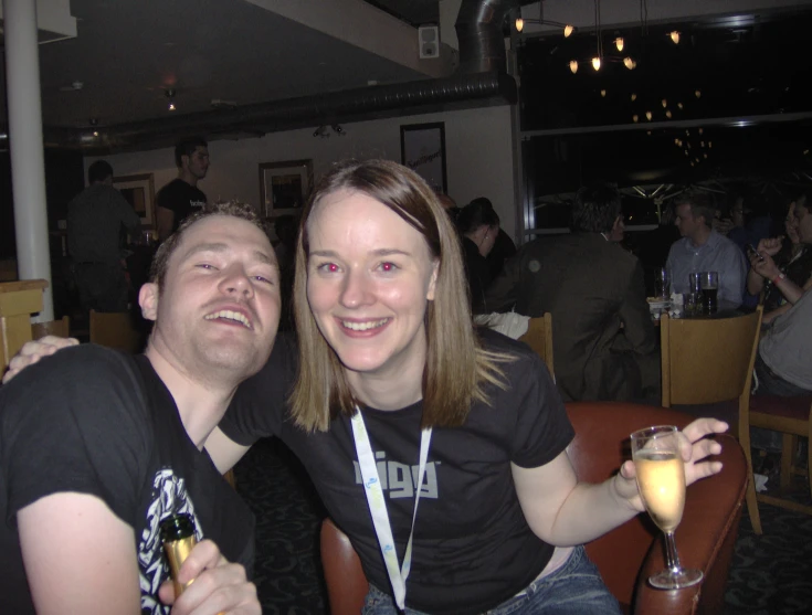 two people at a restaurant one holding a glass of wine