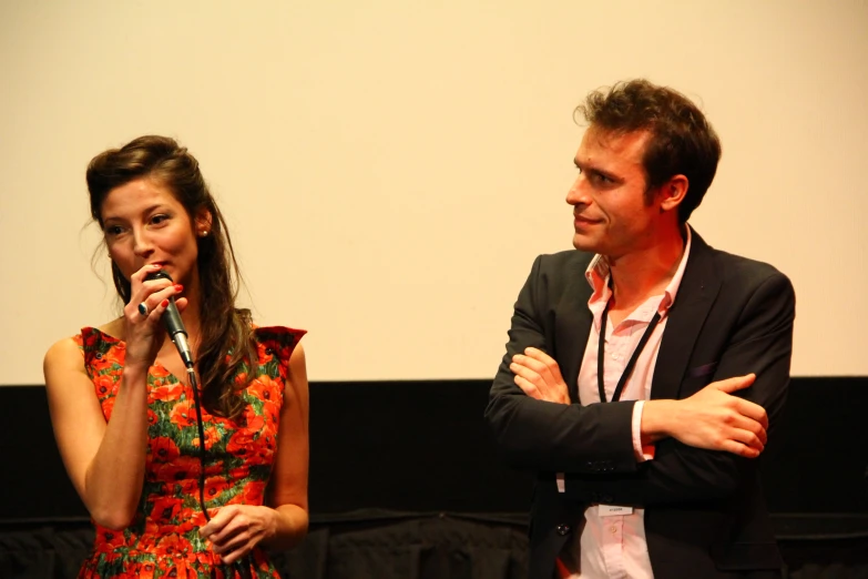 a woman standing next to a man on stage