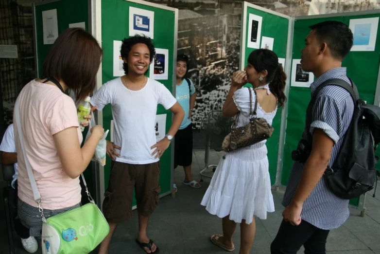 people standing in line in front of a green wall