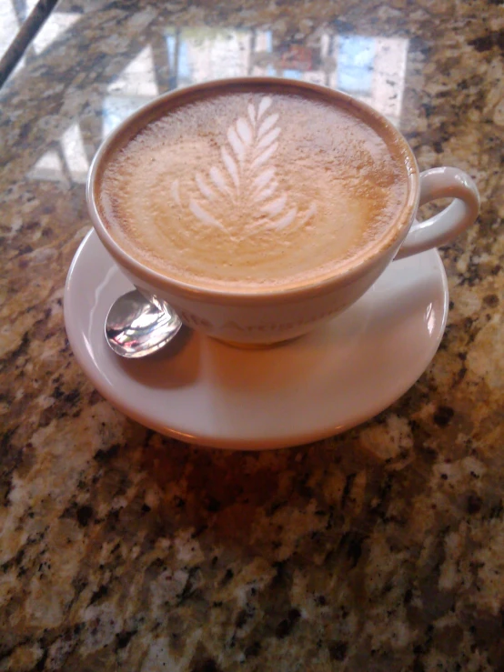 a cup with liquid on it in front of a saucer