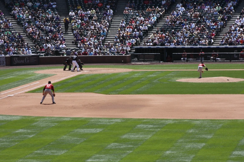 an empty baseball field and a few players are playing