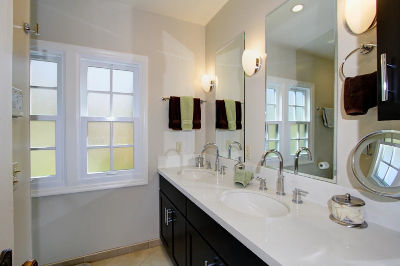 the bathroom has two double sinks and a tub