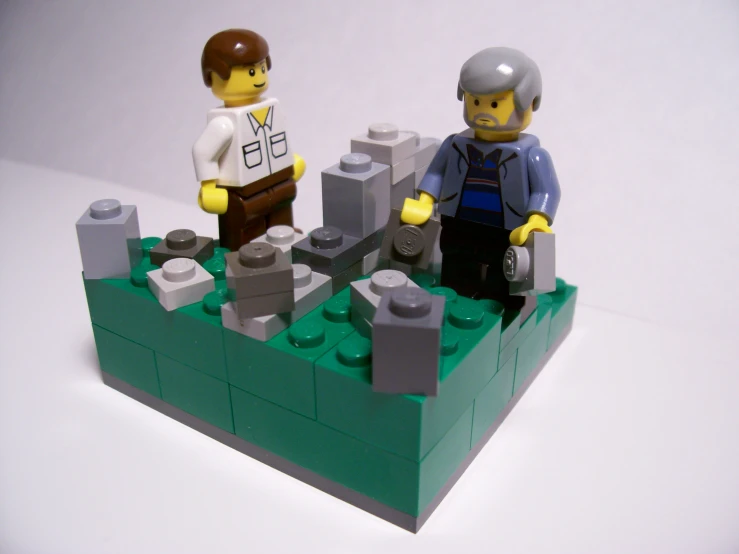 two lego men are standing in front of a castle