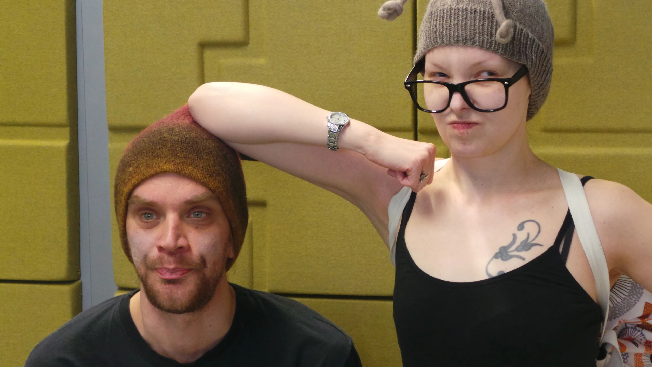 a man sitting next to a woman with glasses on