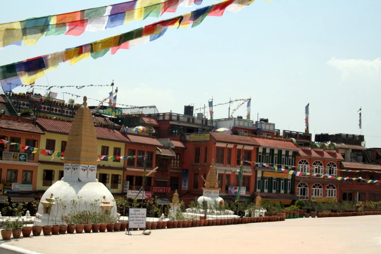 multicolored banners hang from a roof above a row of houses