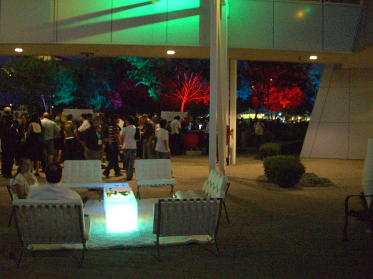 people gathered in a covered area with green lights