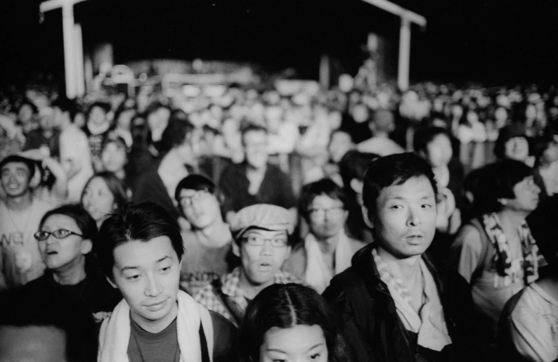 a crowd of people standing around each other