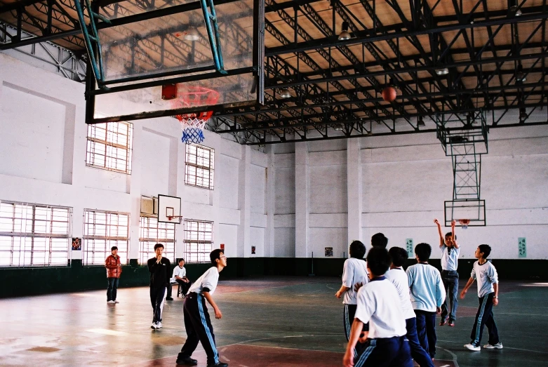 people playing basketball inside an indoor gym