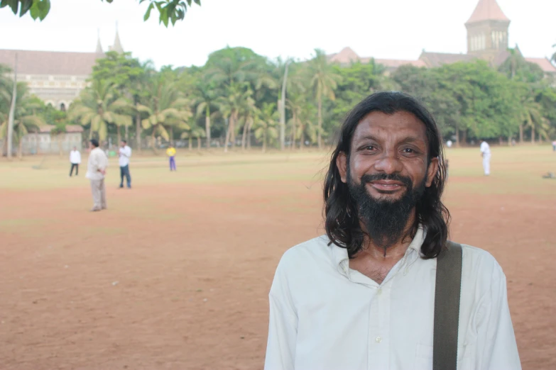 a man with long hair and beard standing on a field