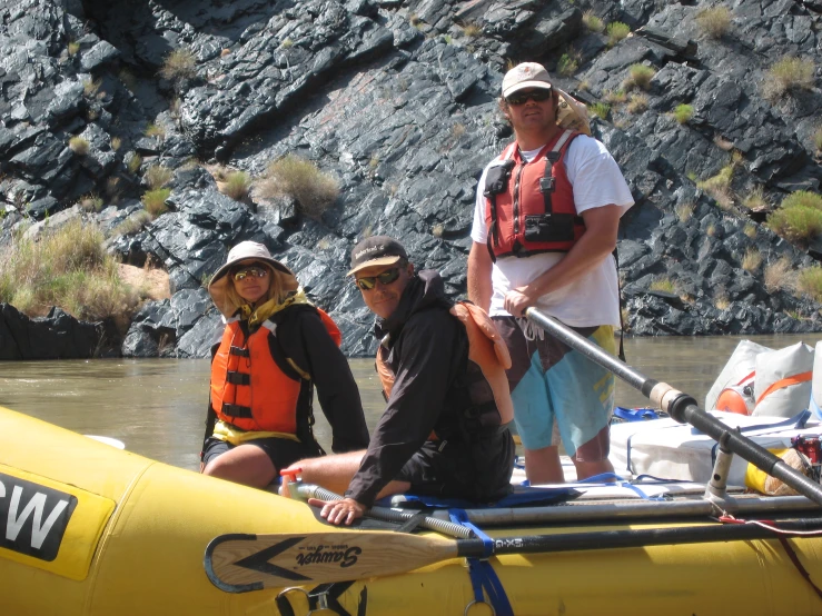 three people posing with paddles on the water