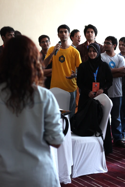 a group of people standing near one another and one holding microphone