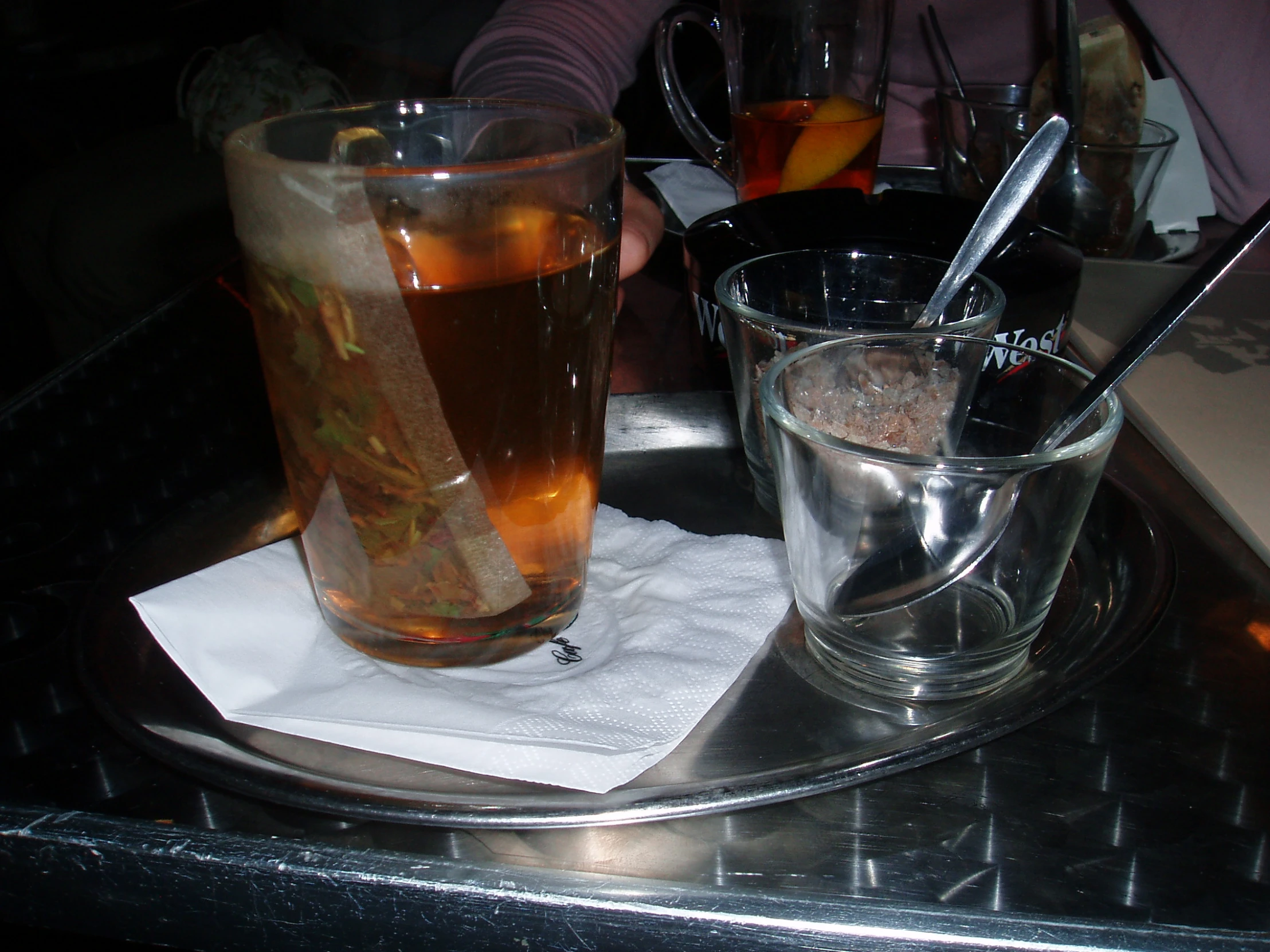 two clear drinking glasses sitting on top of a metal tray