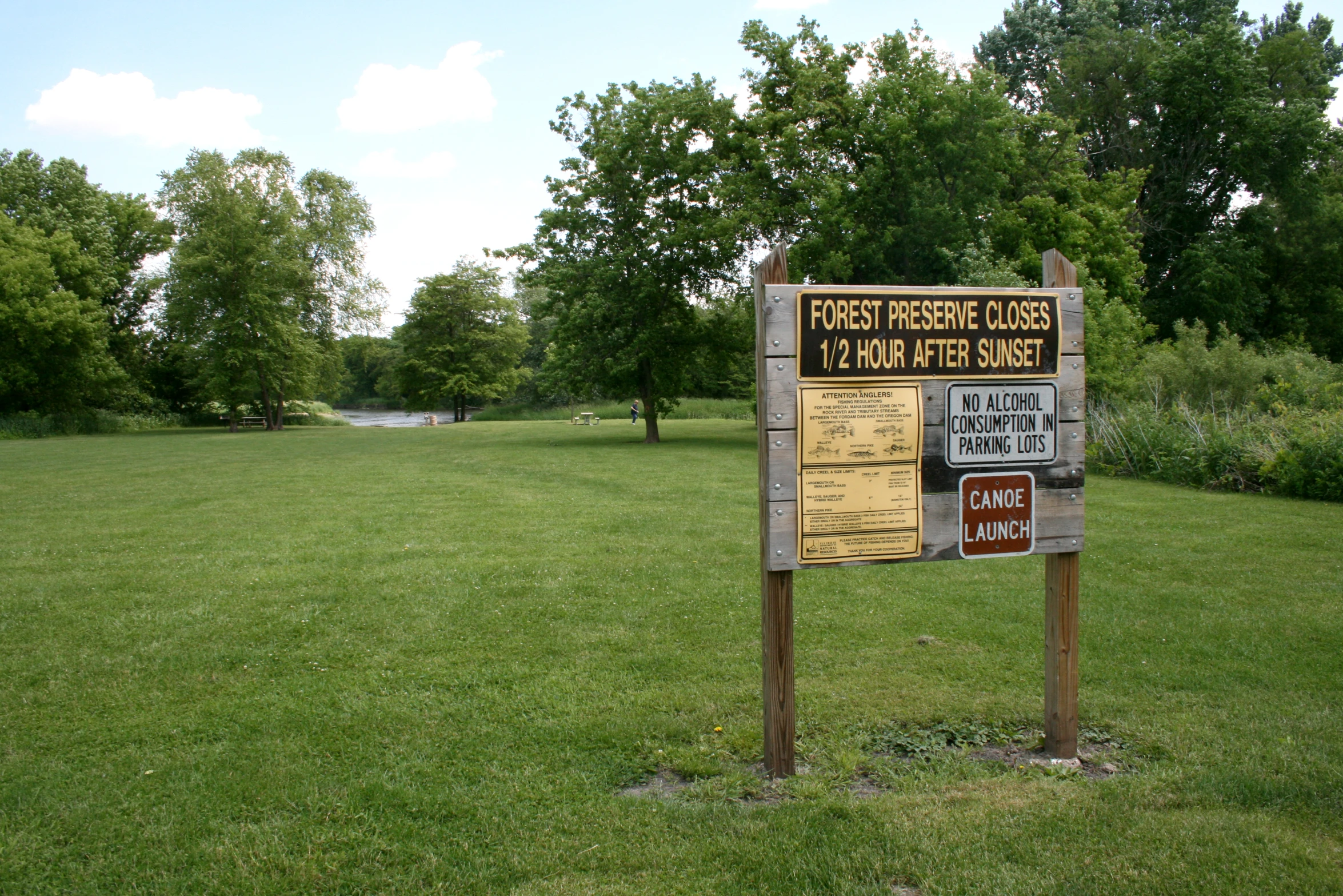 a sign for the post office in a grassy field