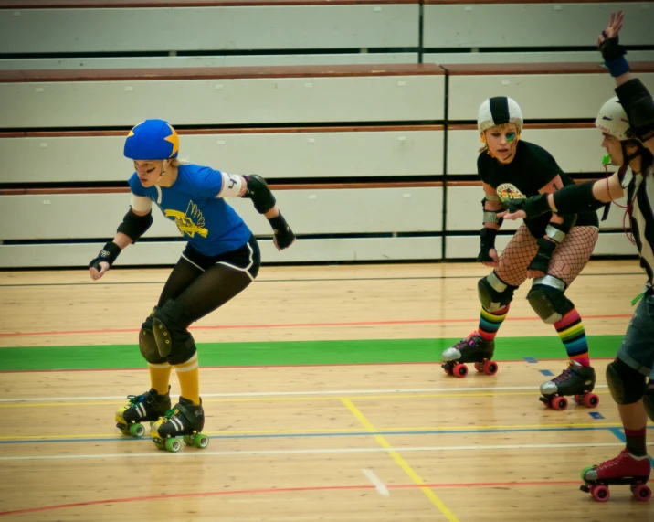 three roller skating in blue are on a hard surface