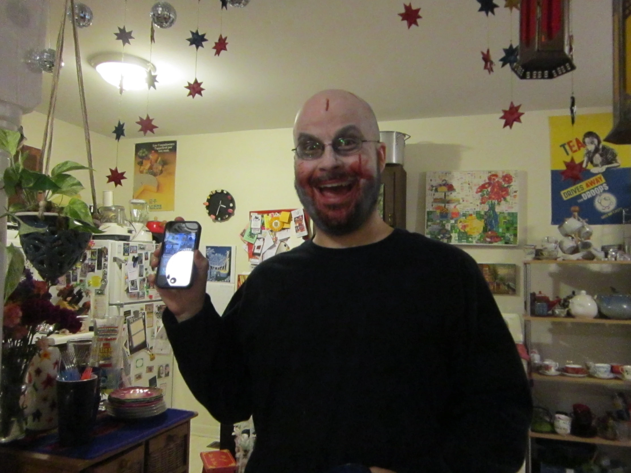 a man with a funny mask holds his cell phone