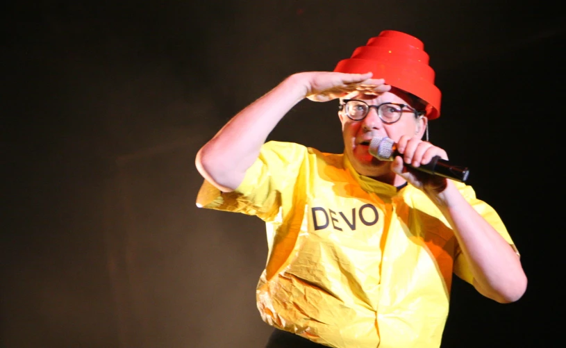 a man in a yellow shirt holding a microphone