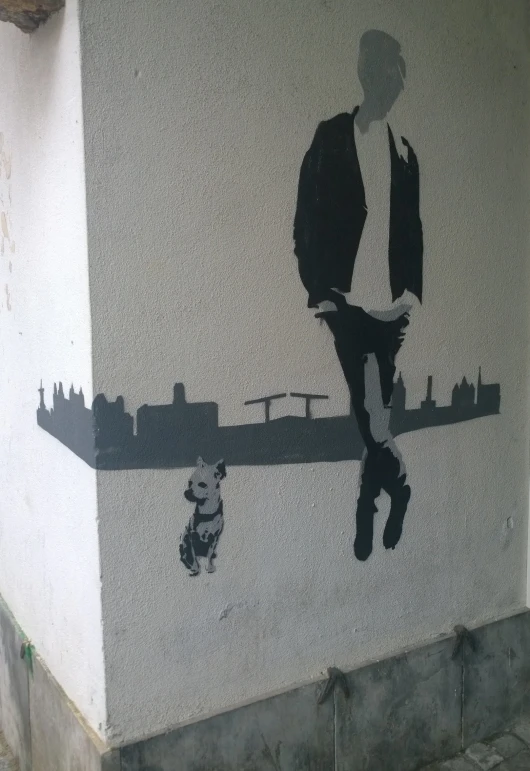 a man is walking near an artwork on a building