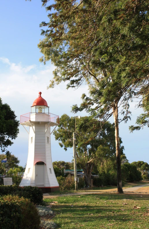 a large white lighthouse on top of a green field