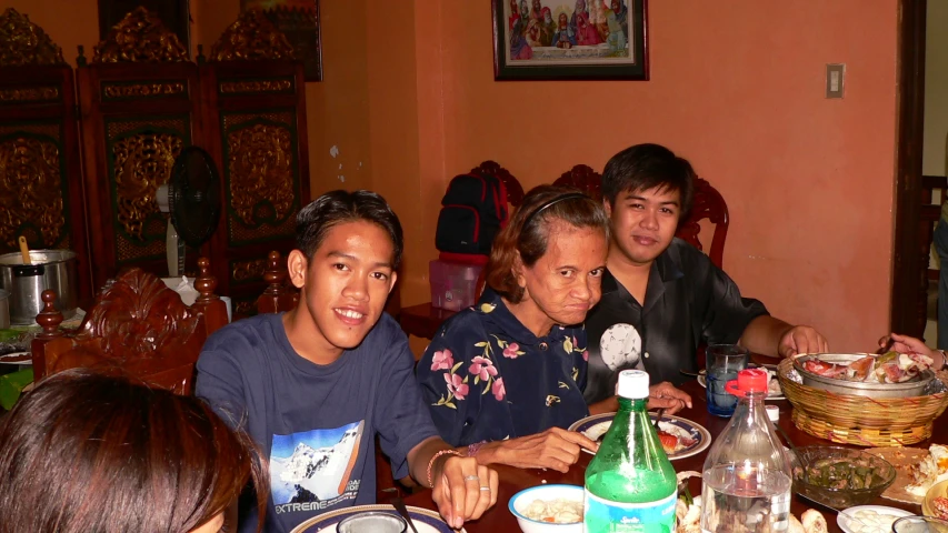 the four people are sitting at the table with food