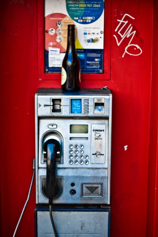 an old machine with a bottle on top of it