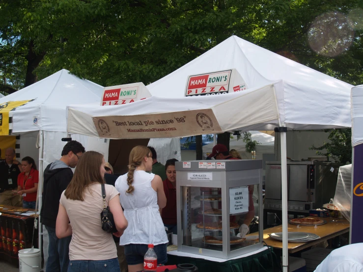 people are buying food at an outdoor fair