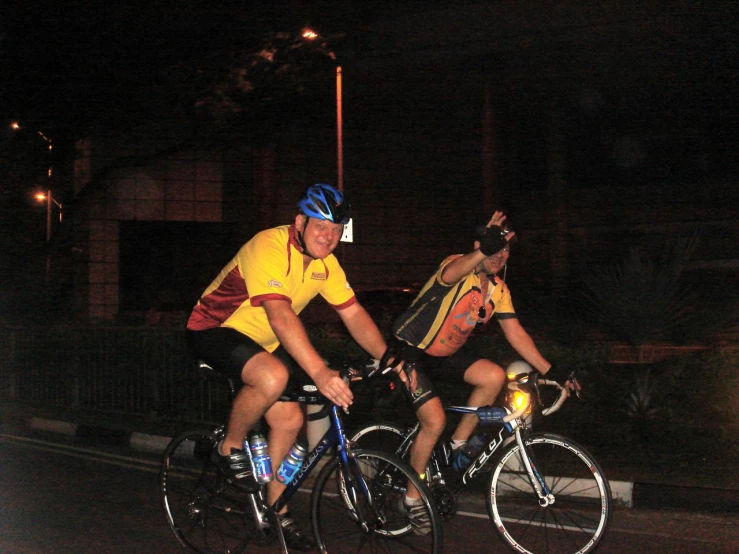 two people riding on a road at night