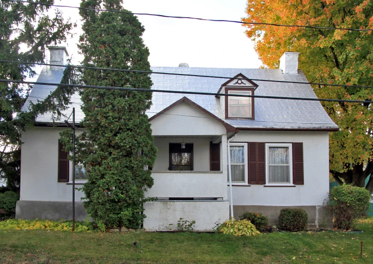 an old white house with a few brown shutters