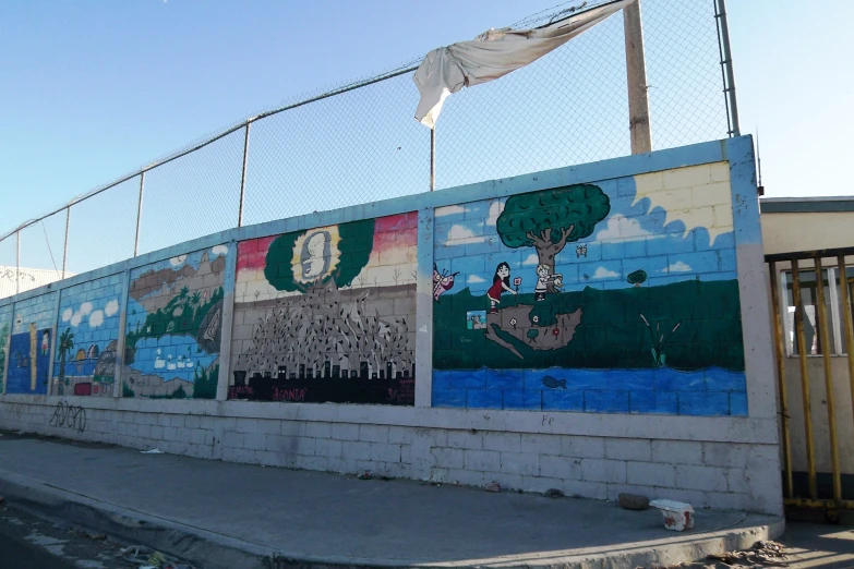 many different wall pictures on a wall near a gate