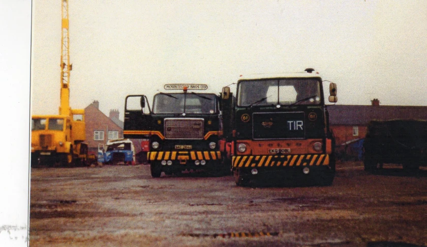 two trucks parked together at the back of a building