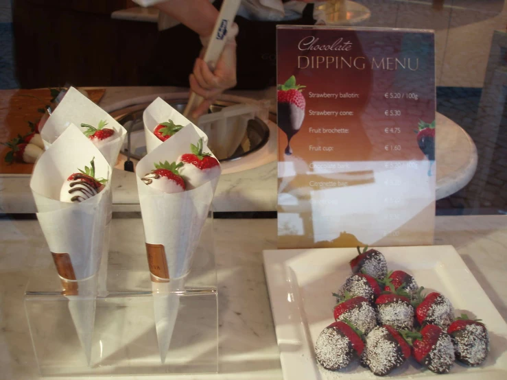 strawberries and chocolate covered strawberries in a paper cone