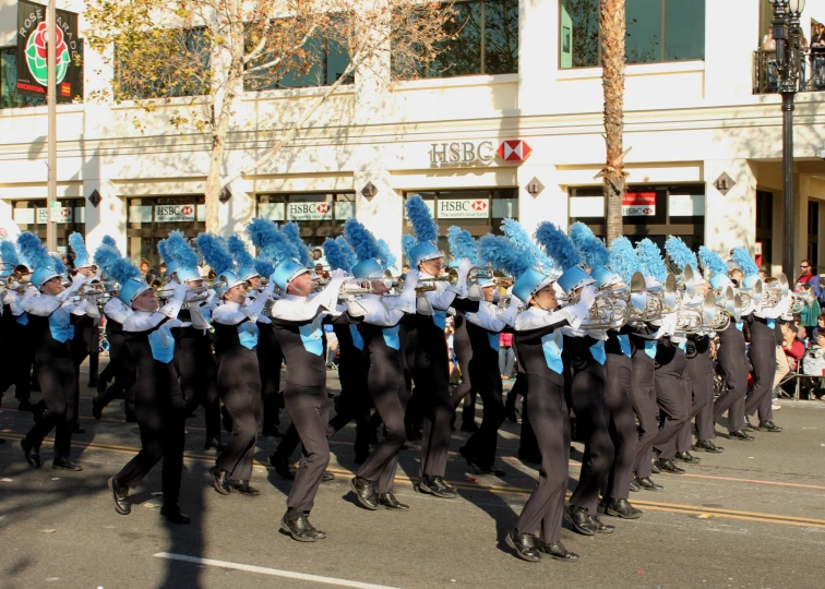 a parade with marching band dressed in blue and white hats