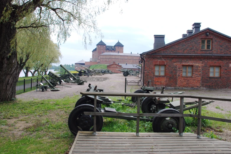 a military cannon next to an old brick building