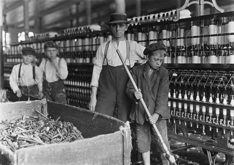 an old black and white po of a boy and three boys are in front of a machine