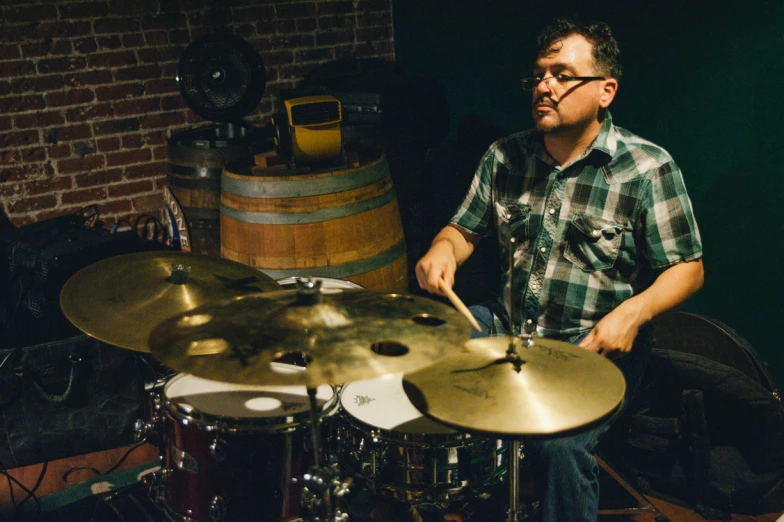 a man sitting at a drum set in a room