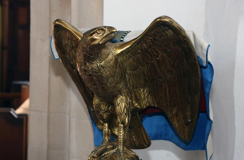 a gold metal statue of an eagle is on display