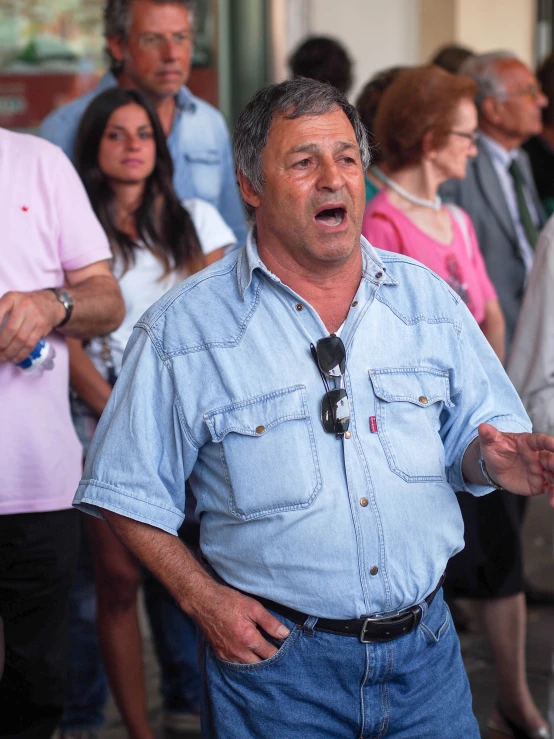 a man holding a microphone standing in front of a group of people