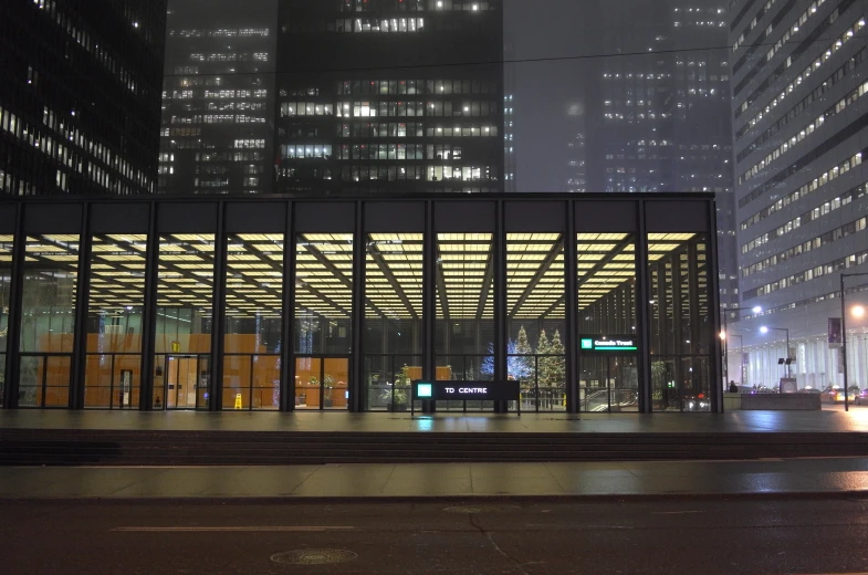 a glass building next to several tall buildings