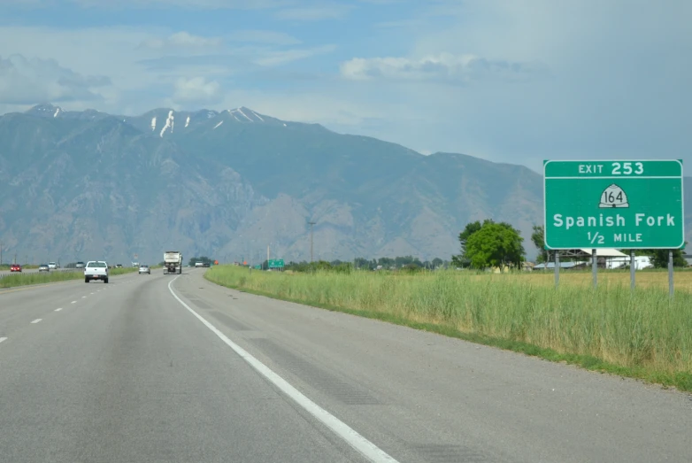 the road with cars driving on it has mountains in the background