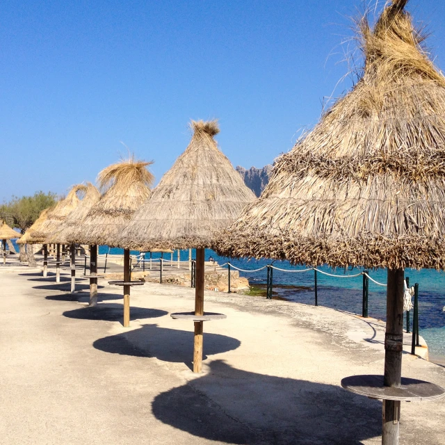 some umbrellas are sitting along the beach