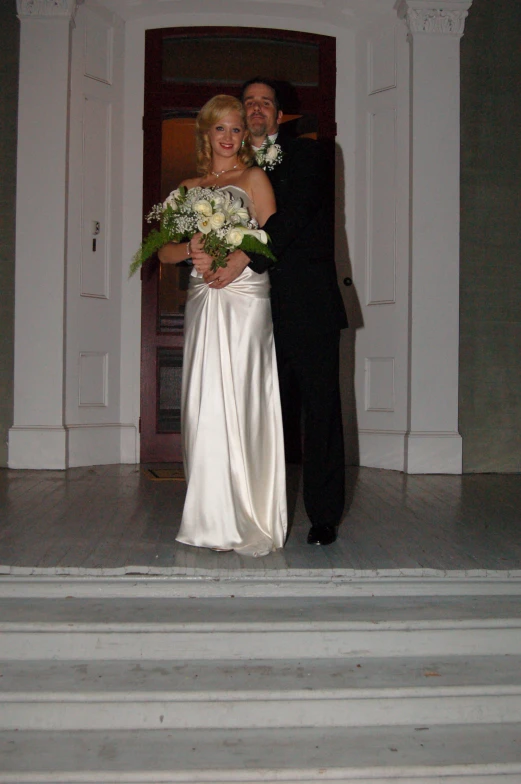 a couple at their wedding with one holding a bouquet