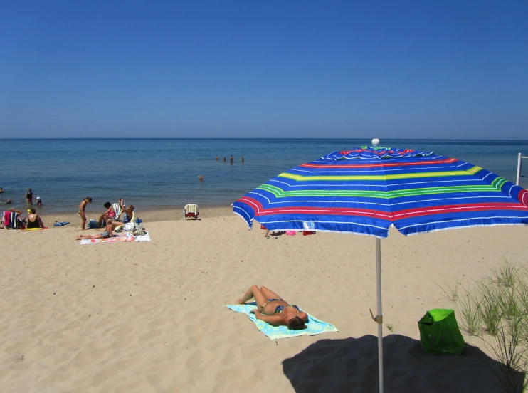 there is a blue striped umbrella on a beach