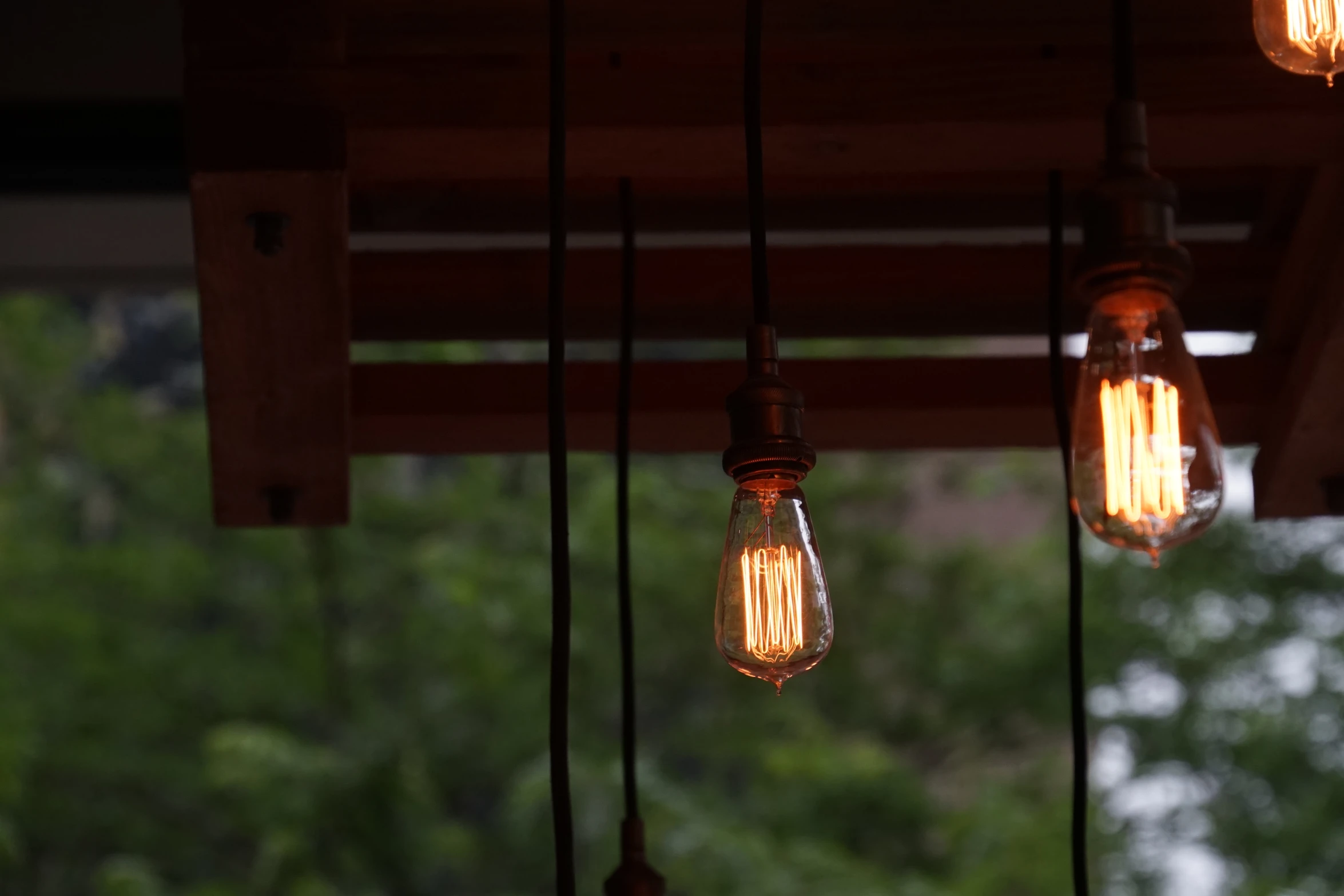 several light bulbs suspended from the roof above a table
